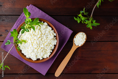 Cottage cheese on wooden boards. Fresh cottage cheese in a ceramic bowl. Soft cheese and wooden spoon on a linen napkin. Top view. Copy space