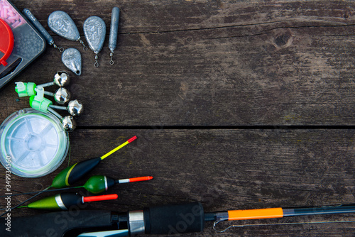 fishing equipment on a wooden table. Floats, sinkers, fishing line, hooks on a wooden background. Flat lay. With place for inscription