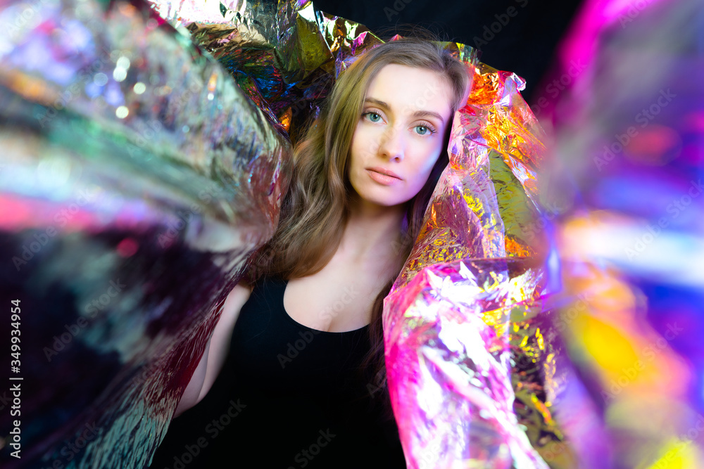 Portrait of a beautiful model girl in a studio, abstract background of shiny red foil iridescent Portrait of a beautiful model girl in a studio, abstract background of shiny red foil iridescent
