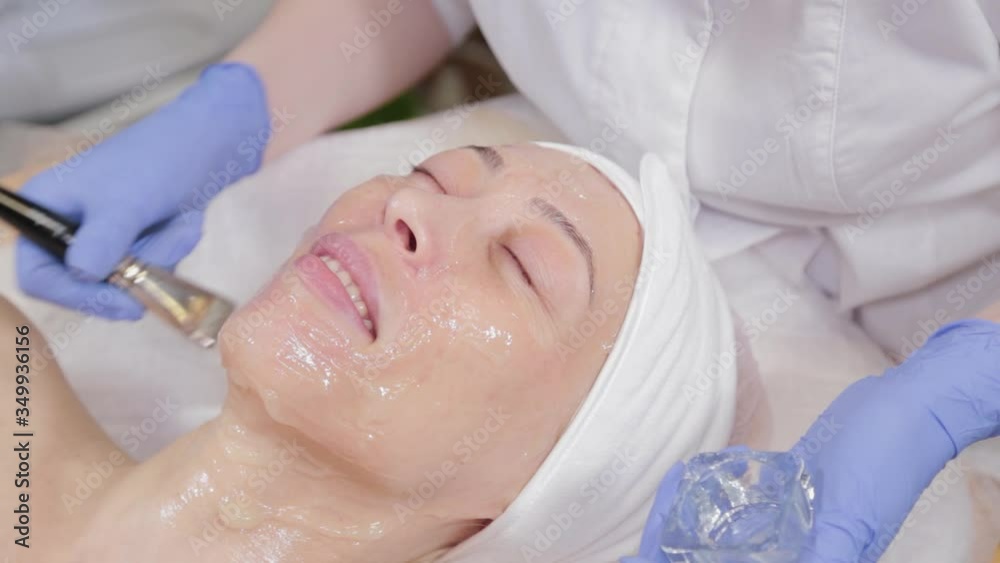 Professional beautician applying a face mask to a woman. Professional beautician applying a face mask to a woman.