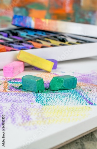 A close up of broken artists soft pastel chalk crayons on an art pad