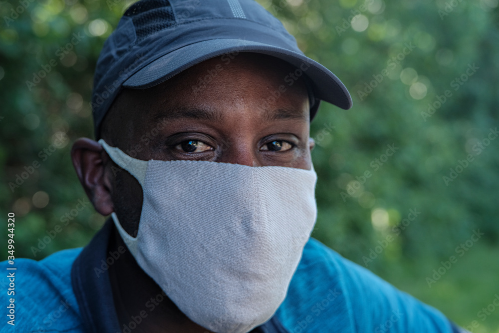 jeune homme noir avec un masque chirurgical et une casquette Stock Photo |  Adobe Stock