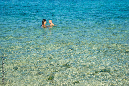 Mom with babies bathe in a transparent ocean in Mauritius