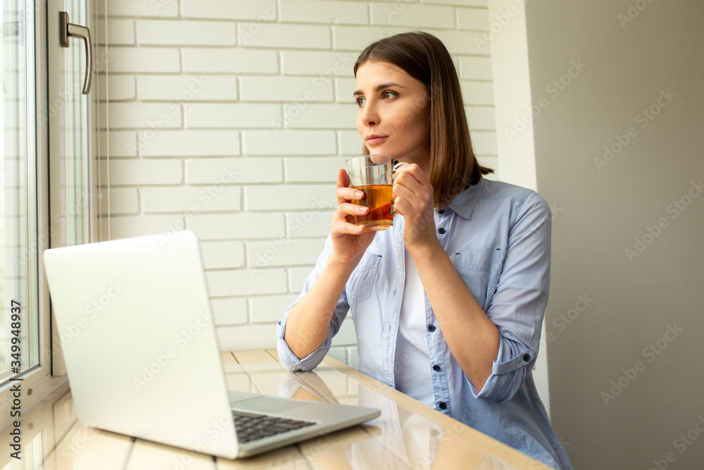Pretty female enjoying tea sitting at table Pretty female enjoying tea sitting at table