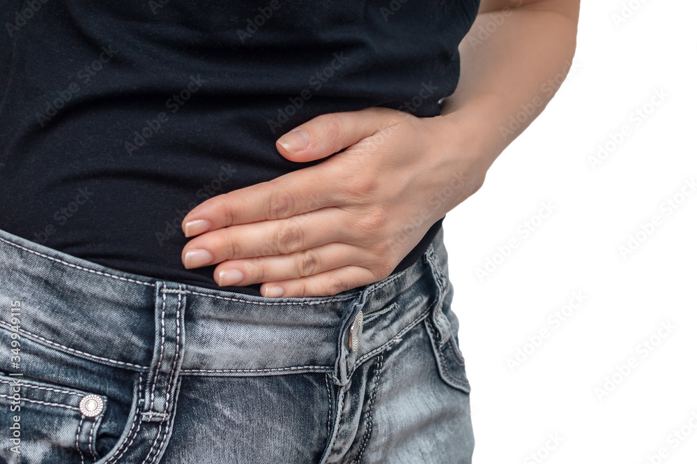 Young woman in jeans and a tshirt holding his stomach in pain closeup