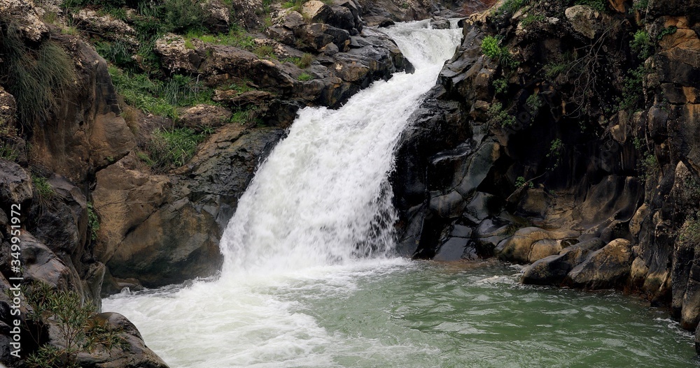 Naklejka premium Waterfalls pour into a lake.