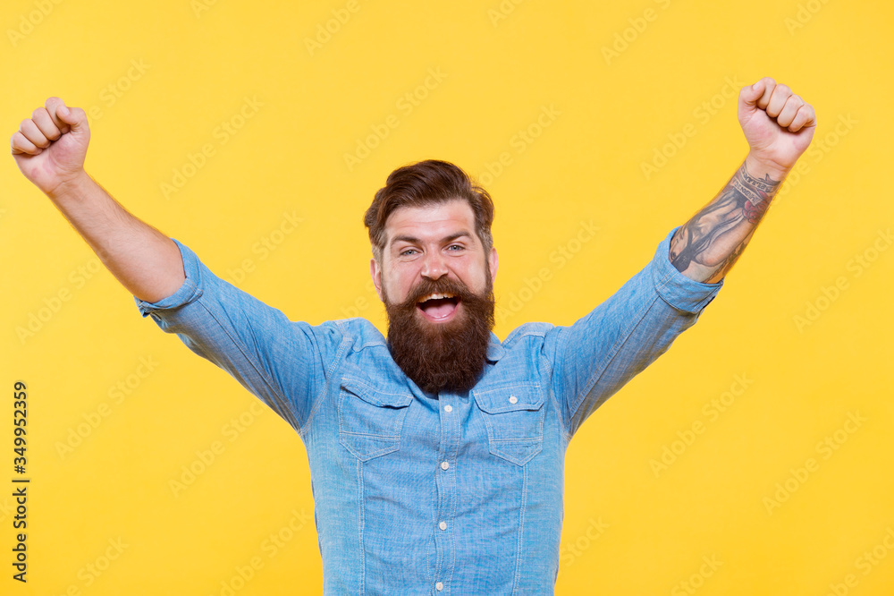 True victory not easy to achieve in life. Happy hipster with raised hands yellow background. Bearded man celebrate victory. Enjoying victory. Victory or success. Hes champion True victory not easy to achieve in life. Happy hipster with raised hands yellow background. Bearded man celebrate victory. Enjoying victory. Victory or success. Hes champion