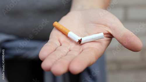 broken cigarette in hand, stop smoking concept, nicotine addiction.