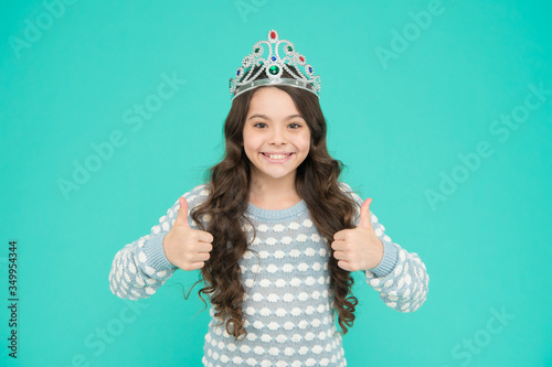 Promoting your content. Happy child give thumbs ups blue background. Princess girl wear crown. Promoting product or service. Sales promotion. Promoting and advertising. Approving and promoting