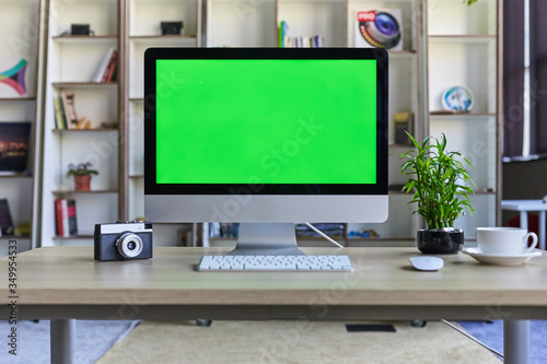 Fotografie Computer desktop with mock-up green screen white background in office and Lovely
