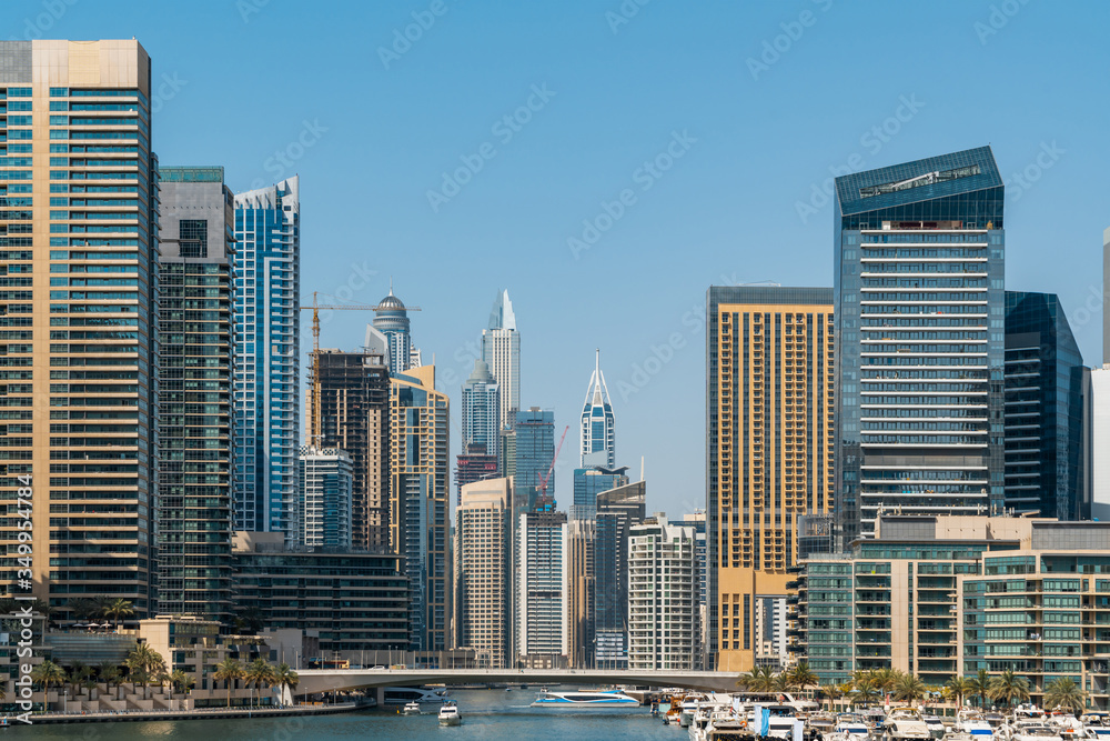 Fototapeta premium Panoramiczny widok na wieżowce Dubaju w Zjednoczonych Emiratach Arabskich. Dubai Marina, prestiżowa dzielnica mieszkaniowa Dubaju, blisko morza. Pojęcie sukcesu finansowego i luksusowego stylu życia.