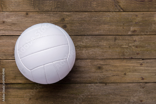 White volleyball ball on old wooden floor