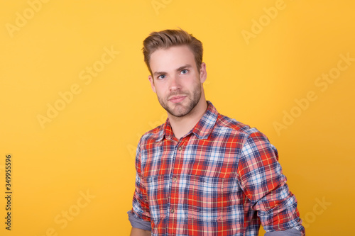 fashion model in shirt. summer and spring male collections. handsome man in checkered shirt on yellow background. sexy and confident. Boy casual style. barber man with cool hairstyle