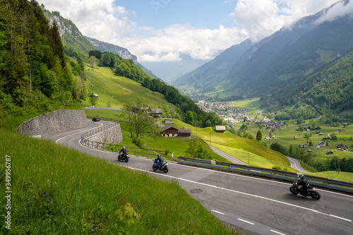 many motorcycles racing down the curvy Klausenpass mountain road in the Swiss Alps near Glarus