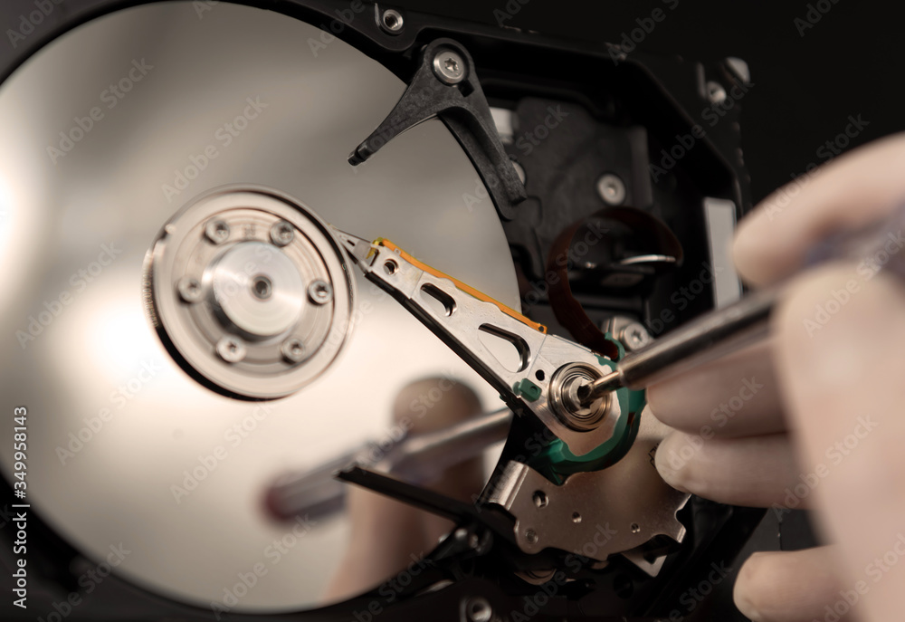 the disassembled hard disk is repaired using tools and rubber gloves to ensure cleanliness the disassembled hard disk is repaired using tools and rubber gloves to ensure cleanliness
