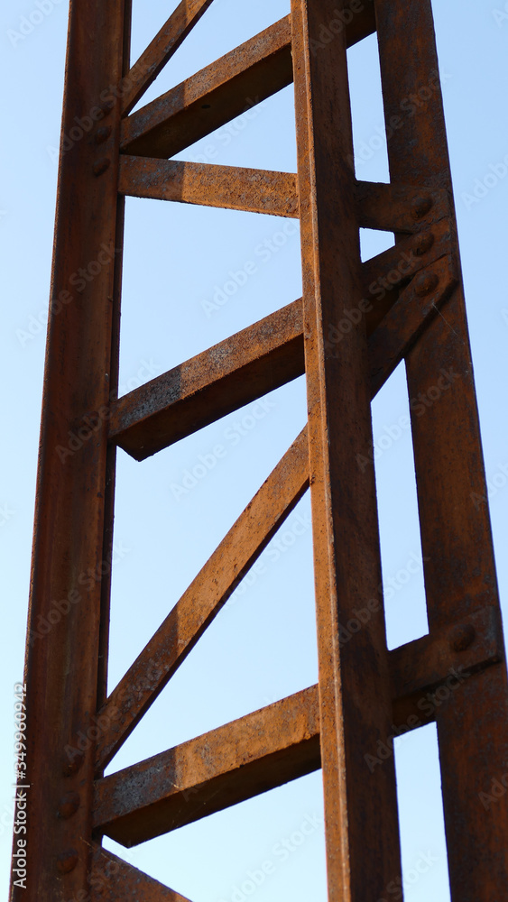 An old disused rusted brown bridge in the countryside connecting two banks across a river, formerly used for busy agricultural traffic An old disused rusted brown bridge in the countryside connecting two banks across a river, formerly used for busy agricultural traffic