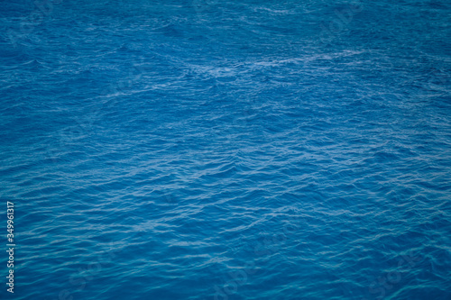 Texture of turquoise blue water. Rich color and slight ripples on the surface. Background and space.