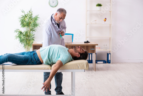 Injured young man visiting old doctor