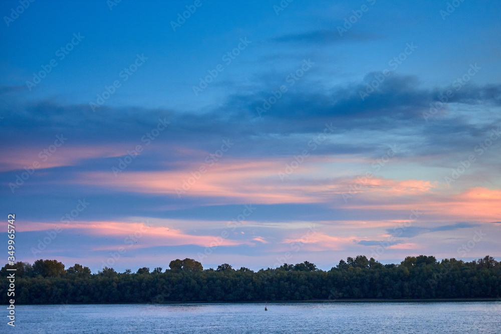 Sunset over danube river delta. Cloudy sky at the evening over river landscape
