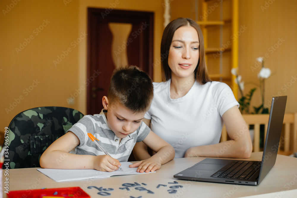 A mother and her child are engaged in distance learning at home in front of the computer. Stay at home, training A mother and her child are engaged in distance learning at home in front of the computer. Stay at home, training