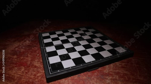 Chess board game concept of business ideas and competition. Empty chessboard on wooden table. Dark background. Selective focus