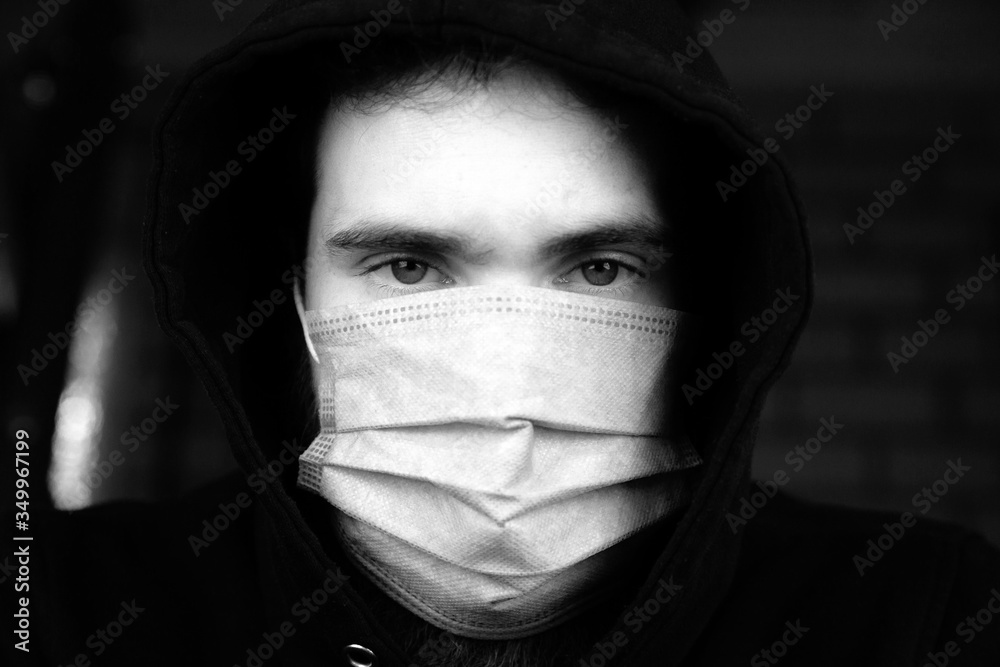 Portrait of young man wearing medical protective face mask for Covid-19 Coronavirus concept. Protect your health. black and white Portrait of young man wearing medical protective face mask for Covid-19 Coronavirus concept. Protect your health. black and white