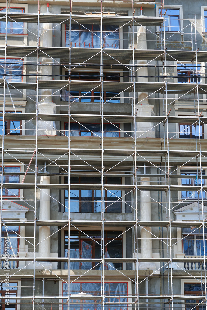 scaffolding at the facade of a building under construction, multi-storey building, without people