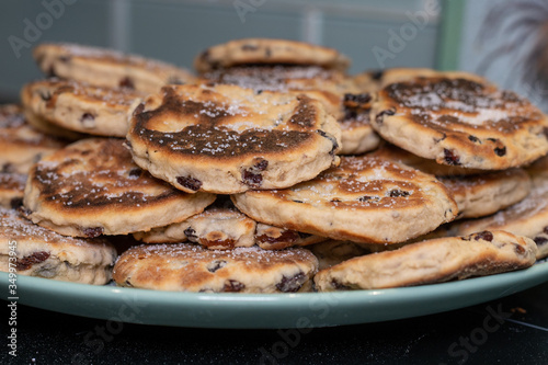 Stack of Homemade Welsh Cakes (Bakestones) freshly cooked on a green plate