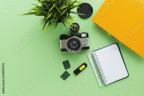 camera, textbook, notebook, pen and memory cards on a green background, the concept of learning  photo