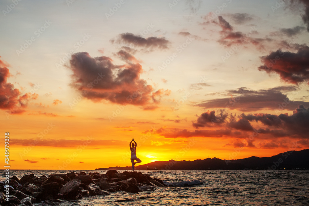 Woman practices yoga at seashore