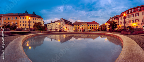 Sophisticated houses and their reflection in well on Bismarckplatz in Regensburg, Germany in early morning during blue hour