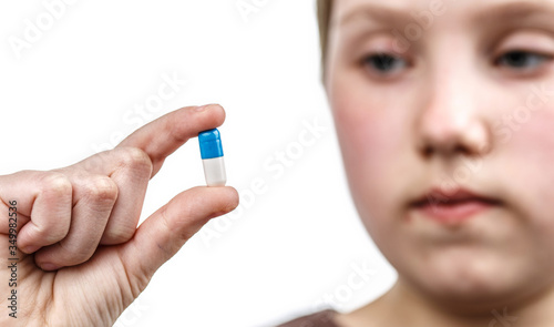 Child holds in the palm a pills.