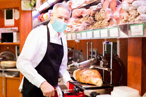 Shopkeeper cutting ham