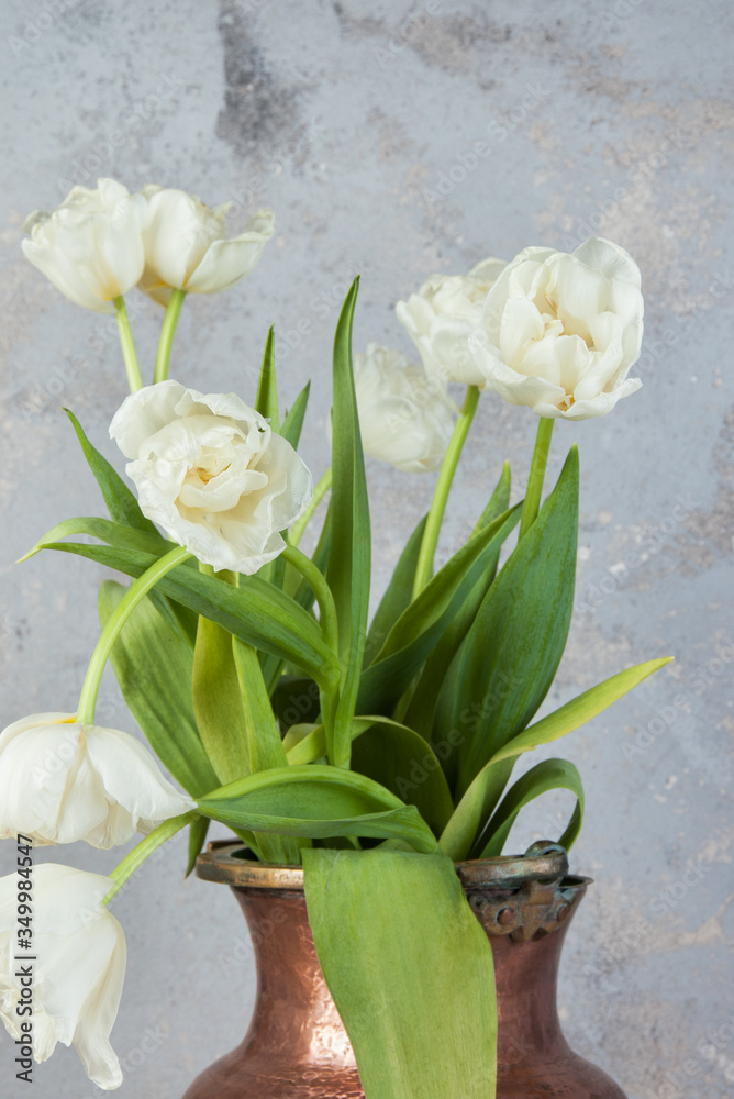 White tulips in old copper vase