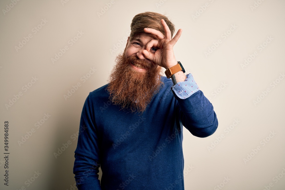 Handsome Irish redhead business man with beard standing over isolated background doing ok gesture with hand smiling, eye looking through fingers with happy face. Handsome Irish redhead business man with beard standing over isolated background doing ok gesture with hand smiling, eye looking through fingers with happy face.