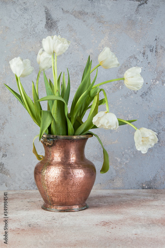 White tulips in old copper vase