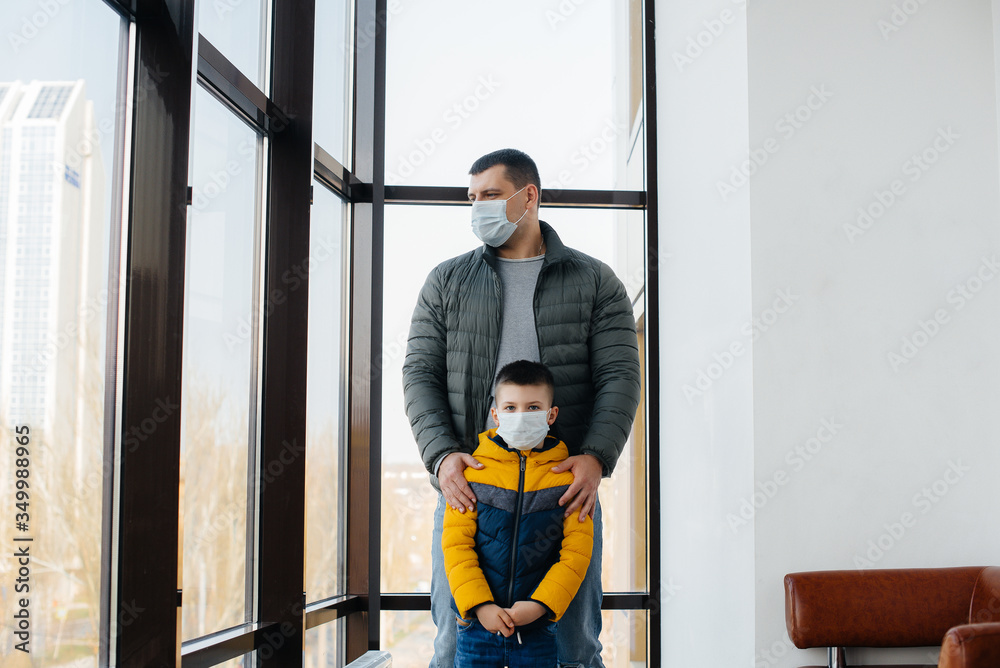 A father with his child stands in a mask during the quarantine. Pandemic, coronavirus