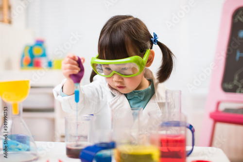 toddler girl pretend play scientist role  at home against white background