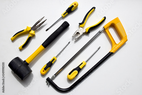 Set of black and yellow working tools, pliers, wire cutters, screwdrivers, hammer and saw which can be used to repair, build, improve, fix by carpenter, repairman, mechanic, handyman