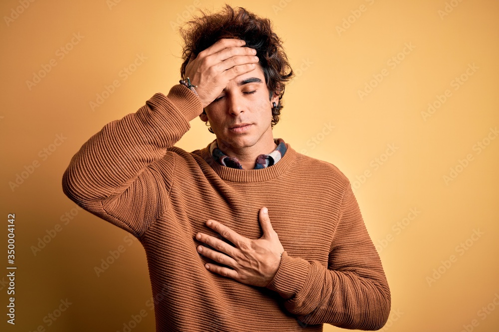 Young handsome man wearing casual shirt and sweater over isolated yellow background Touching forehead for illness and fever, flu and cold, virus sick Young handsome man wearing casual shirt and sweater over isolated yellow background Touching forehead for illness and fever, flu and cold, virus sick