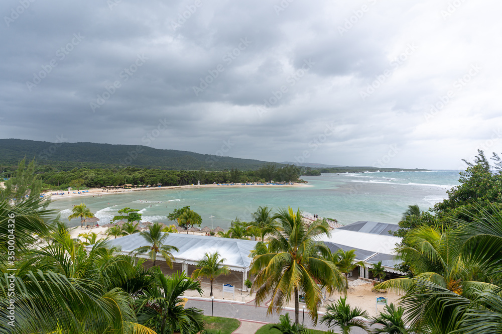 wide angle shot of a beautiful tropical resort beach scene on a gray cloudy day