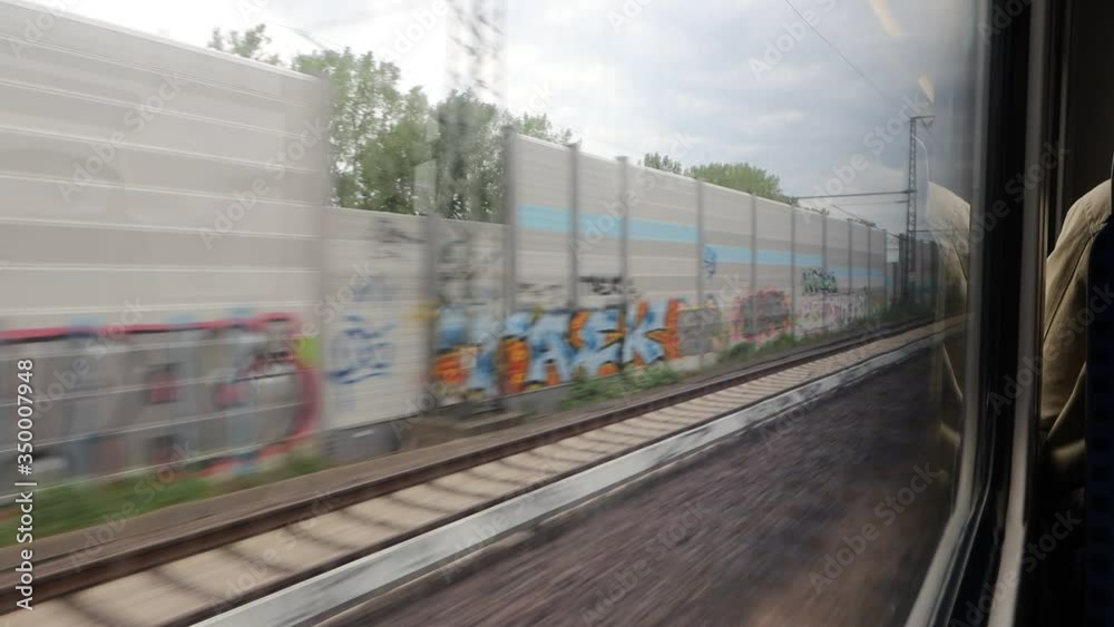 The view Through dirty Window of a moving commuter train in Hamburg on the fields sweeping outside the window The view Through dirty Window of a moving commuter train in Hamburg on the fields sweeping outside the window