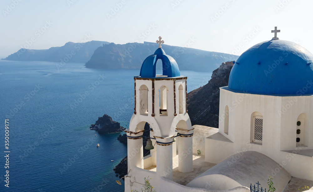 Blue dome church with belltower on the cliff of Oia, Santorini, Greece