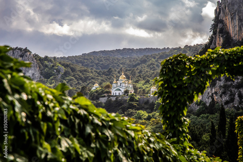 Beautiful view of the vineyards, dramatic sky, mountains and Orthodox Church in the distance. Crimea. Selective focus.