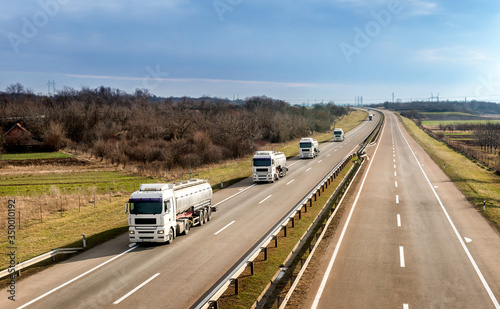 Convoy or Fleet of Tank trucks on a winding Highway through the rural landscape