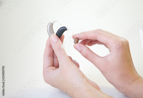 Three different hearing aids in female hands