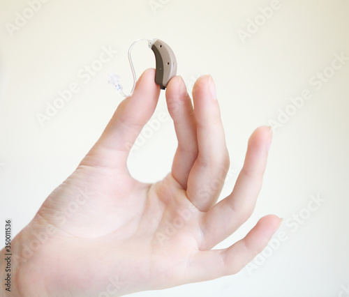 Very small hearing aid in female hands