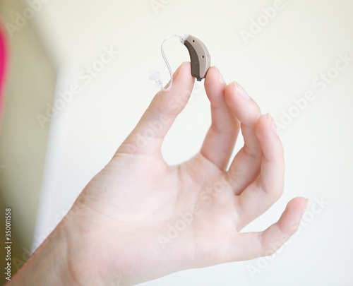 Very small hearing aid in female hands