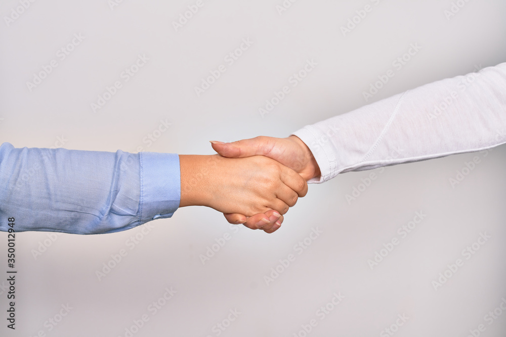 Handshake of two hands of young caucasian businesswomen for agreement over isolated white background Handshake of two hands of young caucasian businesswomen for agreement over isolated white background