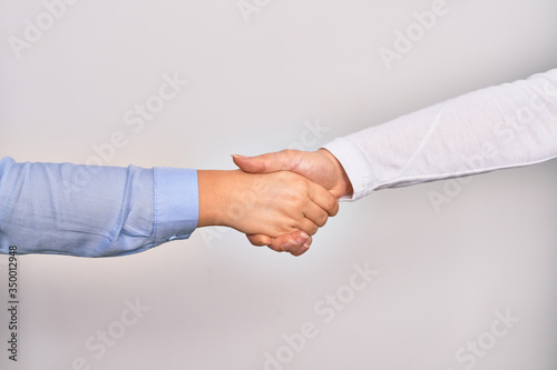 Handshake of two hands of young caucasian businesswomen for agreement over isolated white background
